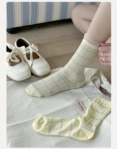 Close-up of light yellow striped cotton crew socks with breathable ribbed mesh texture