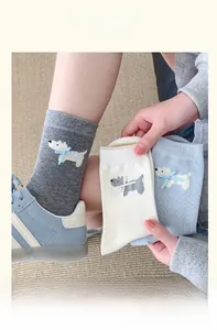 Close-up of knit crew socks with cartoon dog patterns and 3D bowknot details