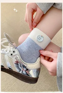 Detail of blue speckled mid-calf sock with a plaid apple button decoration