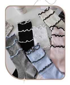 Detail of ruffled edges and striped knit texture on multi-color cotton crew socks