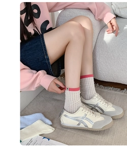 Detail of Korean style ribbed socks with pink trim paired with stylish silver striped sneakers