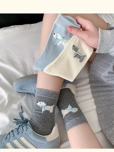 Detail of cute West Highland terrier socks with blue bows in gray, blue, and cream