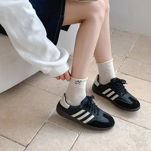 Schwarz-weiße Freizeitschuhe mit drei Streifen getragen mit weißen Crew-Socken