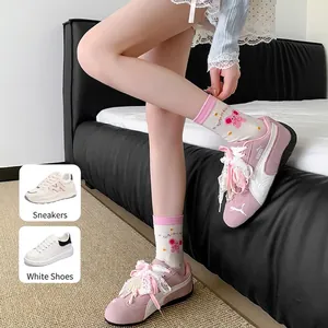 Pink platform sneakers featuring delicate lace shoelaces and decorative pearl charms