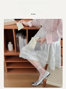 Dettaglio di calze al polpaccio in cotone rosa con pizzo bianco e decori floreali