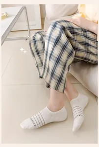 Detail of white invisible low-cut socks with grey stripes and breathable knit texture