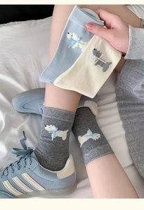 Detail of Westie puppy socks featuring 3D blue ribbon bows and cute knit pattern