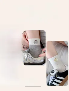 Detail of knit socks with apple button accent and speckled texture in sneakers