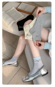 Dettaglio di calzini in stile ballerina con fiocchi laterali e scarpe ballerine