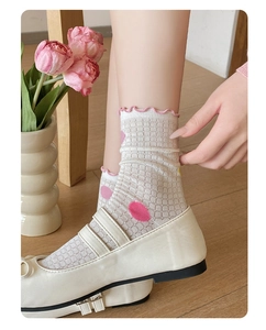 Detail of white mesh mid-calf socks with pink polka dots and ruffled edge trim