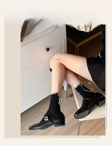 Detail of black Mary Jane shoes with metal flower buckle and knit lace trim socks