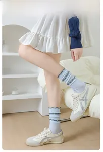 Detailed view of light blue ribbed crew socks with dark grey agaric lace trim and soft texture