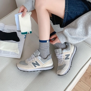 Women's college style striped mid-calf socks shown with retro sneakers in blue and grey