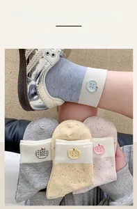 Detail showing elastic rib cuffs and plaid apple buttons on colorful cotton socks
