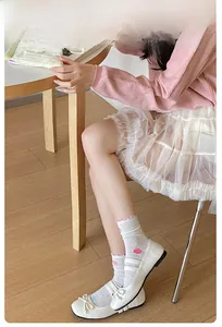 Detail of white mesh socks with colorful polka dots and pink agaric lace edge