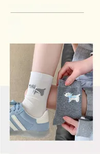 Detail of Westie dog embroidery and ribbon bows on ribbed cotton mid-calf socks