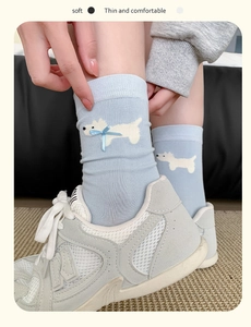 Detail of light blue crew socks featuring cartoon dog patterns and 3D silk bow accents