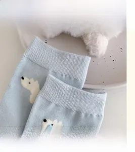 Detail view of high-elasticity ribbed cuffs on blue socks with cute polar bear patterns