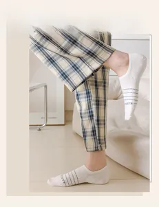 Close-up of low-cut invisible cotton socks with gray stripes and letter knit detail
