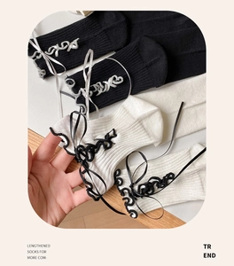 Detailed view of Lolita style mid-calf socks with ribbon lace-up and bow decoration
