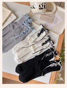 Detailed view of sweet lace socks with side ribbon bows in grey, white and black colors