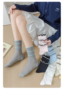 Close-up of ribbed cotton socks with contrasting ruffled cuffs and lace trim detail
