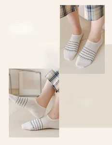 Close-up of white invisible boat socks featuring blue stripes and letter patterns