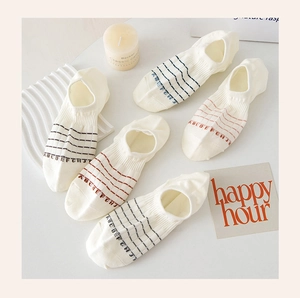 Close-up of five pairs of cotton invisible socks with colorful stripes and letter prints
