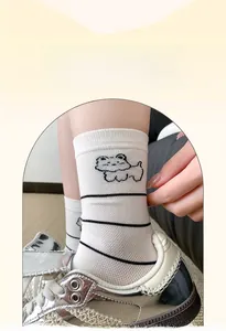 Detail of white cotton mid-calf socks with black stripes and cute cartoon dog pattern