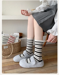 Close-up of black and white striped cotton socks with speckle knit and Mary Jane shoes