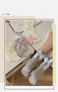 Detailed view of mesh socks featuring large ribbons in grey, cream, pink, and lilac tones