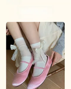 Detail of ballet style lace bow mid-tube socks paired with pink Mary Jane shoes