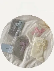 Detail view of mesh socks set featuring elegant lace bows in individual packaging