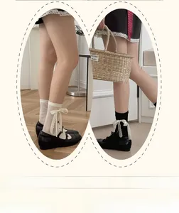 Detail of sweet Lolita style mid-calf socks with lace ribbons in black and white colors