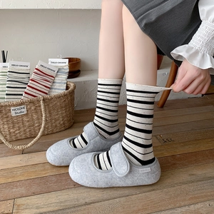 Striped cotton crew socks with colorful flecks and rolled edges shown in a home setting