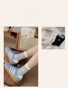 Detail of rib-knit crew socks with embroidered bows and hearts in various colorways