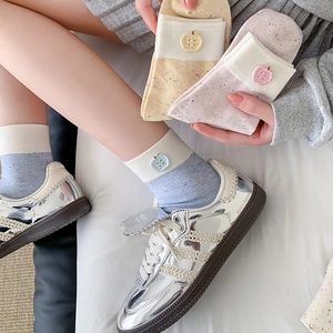 Three pairs of pastel cotton crew socks featuring apple-shaped buttons and ribbed cuffs