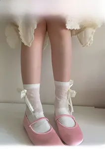 Detail showing white lace crew socks with bow ribbons paired with Mary Jane shoes