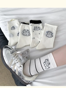 Close-up of five pairs of white cotton socks featuring various cute cartoon bear patterns