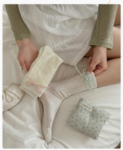 Détail rapproché de chaussettes en maille côtelée avec nœuds roses et vert menthe