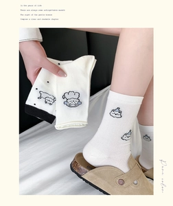 Detail of white cotton calf socks featuring cute puppy patterns and breathable mesh texture