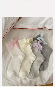 Close-up of mesh cotton socks featuring large bows and wavy ruffles in four soft colors