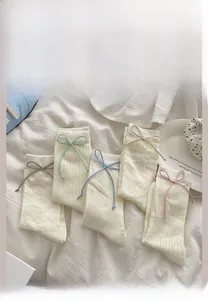 Détail de cinq paires de chaussettes blanches en résille avec nœuds et motifs variés