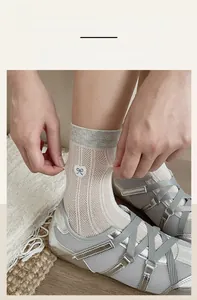 Close-up showing the stretch and elasticity of mesh socks with embroidered heart bow