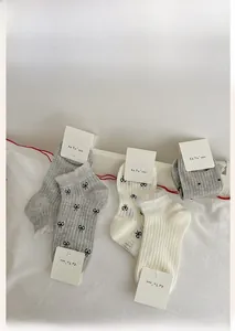 Detail of lace trim ankle socks with bow prints and ribbed texture on display card