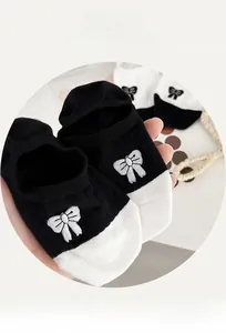 Detail of cotton boat sock with black and white splicing and white bow embroidery