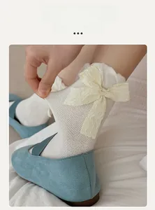 Detail of white lace mesh sock with bow, showcasing high elasticity and texture