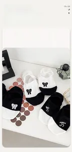 Detail of low-cut cotton socks with bow embroidery and contrasting black and white design