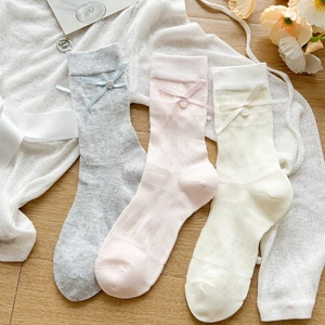 Detailed knit texture and decorative bow buttons on stylish mesh crew socks