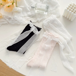 Close-up of lace ribbon socks in black, pink, and white with elegant polka dot patterns